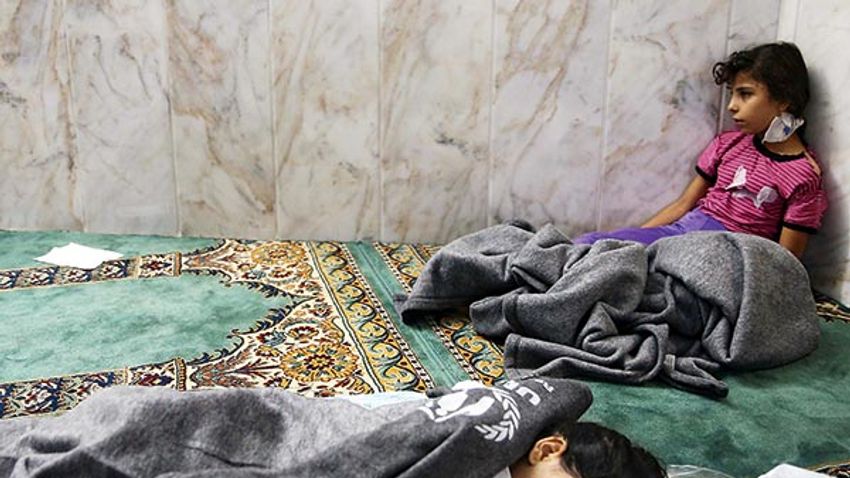 Girls who survived from what activists say is a gas attack rest inside a mosque in the Duma neighbourhood of Damascus