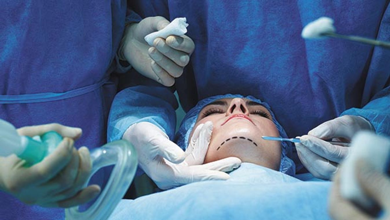 Young woman lying on operating table during facial plastic surgery