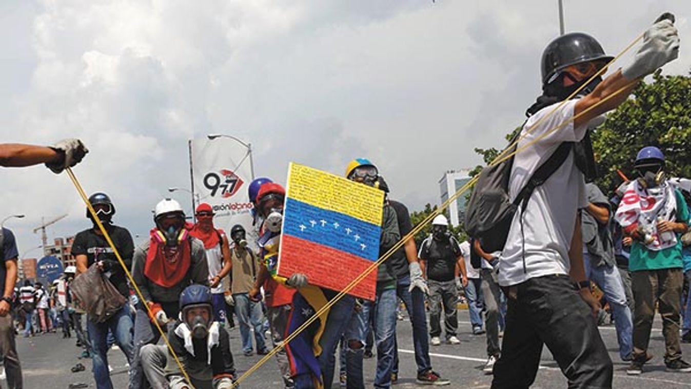 Opposition supporters uses a giant sling shot to throw a "Poopootovs", a bottle filled with feces, which is a play on Molotov, during a rally against President Nicolas Maduro in  Caracas