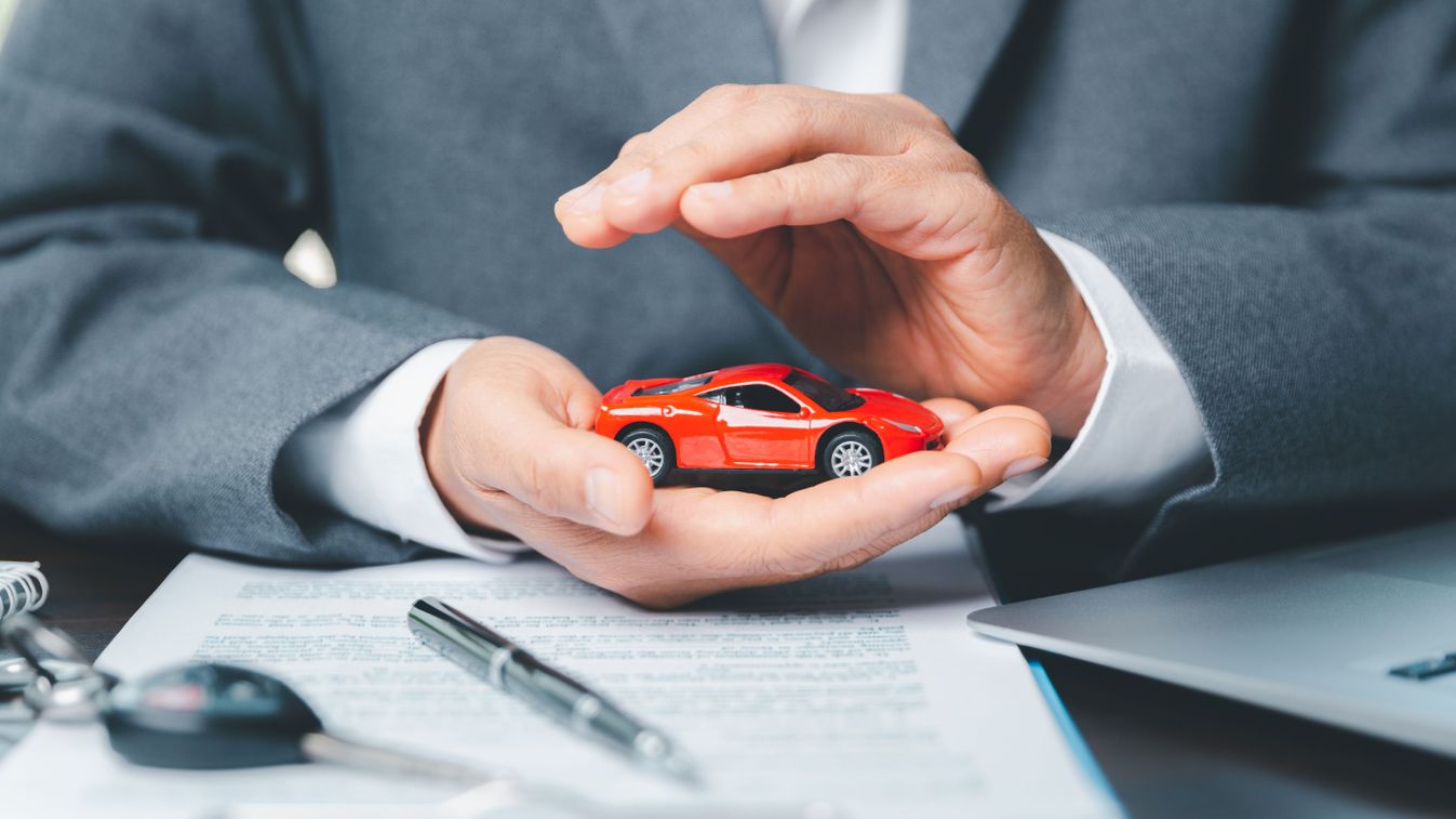 Business,Woman's,Hand,Protecting,Red,Toy,Car,On,Desk.,Planning