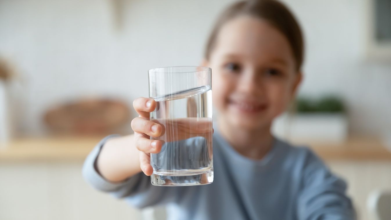 Close,Up,Smiling,Little,Girl,Holding,Glass,Of,Pure,Mineral