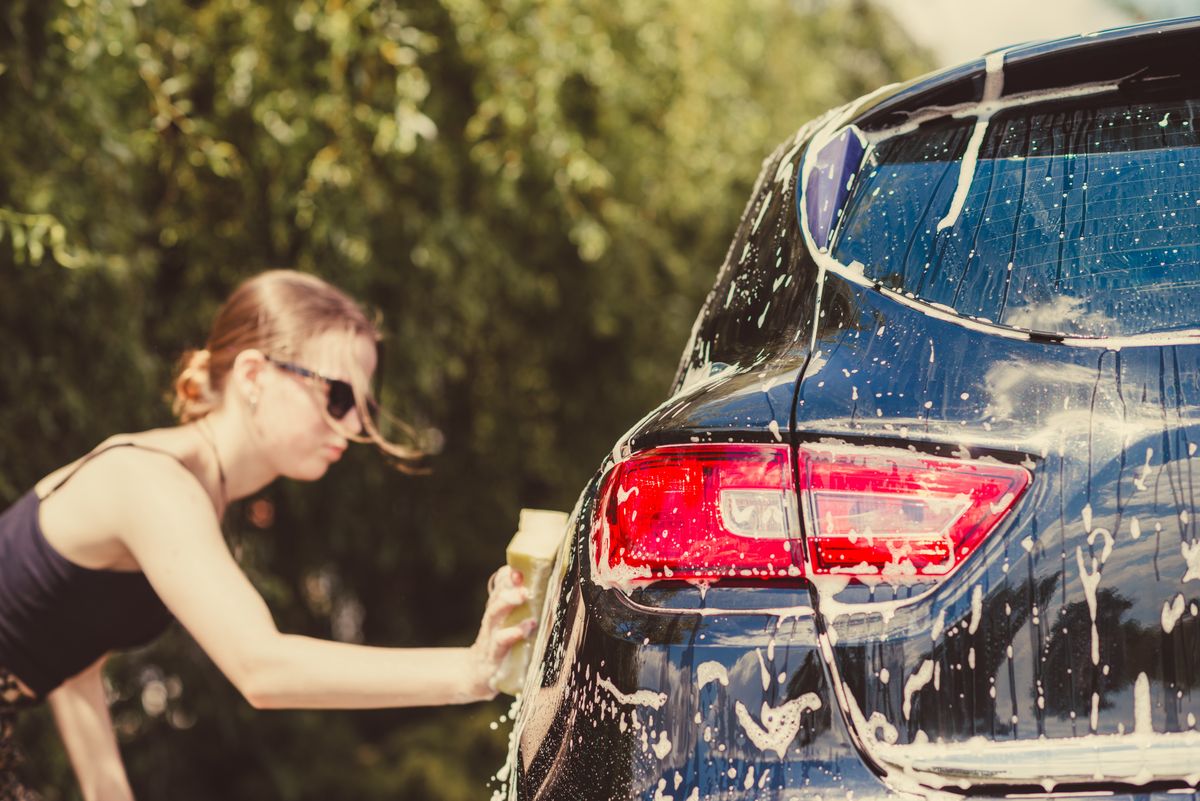 Woman,Washing,Car,With,Sponge,On,A,Sunny,Day