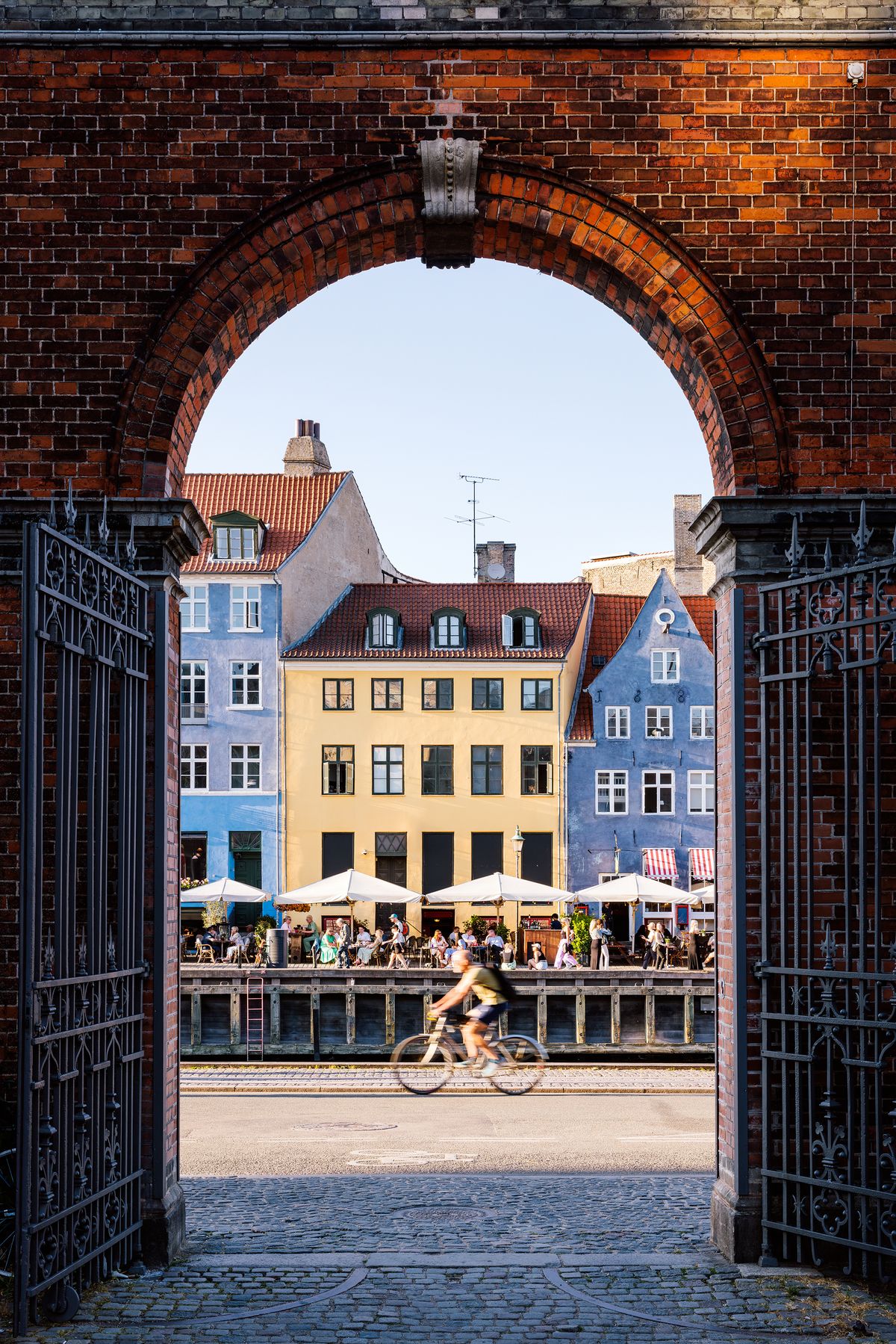 Cyclist riding past Nyhavn harbour on a sunny summer day, Copenhagen, Denmark