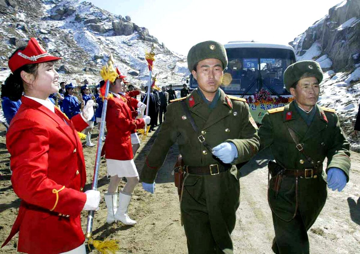 NORTH KOREAN SOLDIERS WALK PAST A TOUR BUS FOR SOUTH KOREANS IN NORTH KOREA