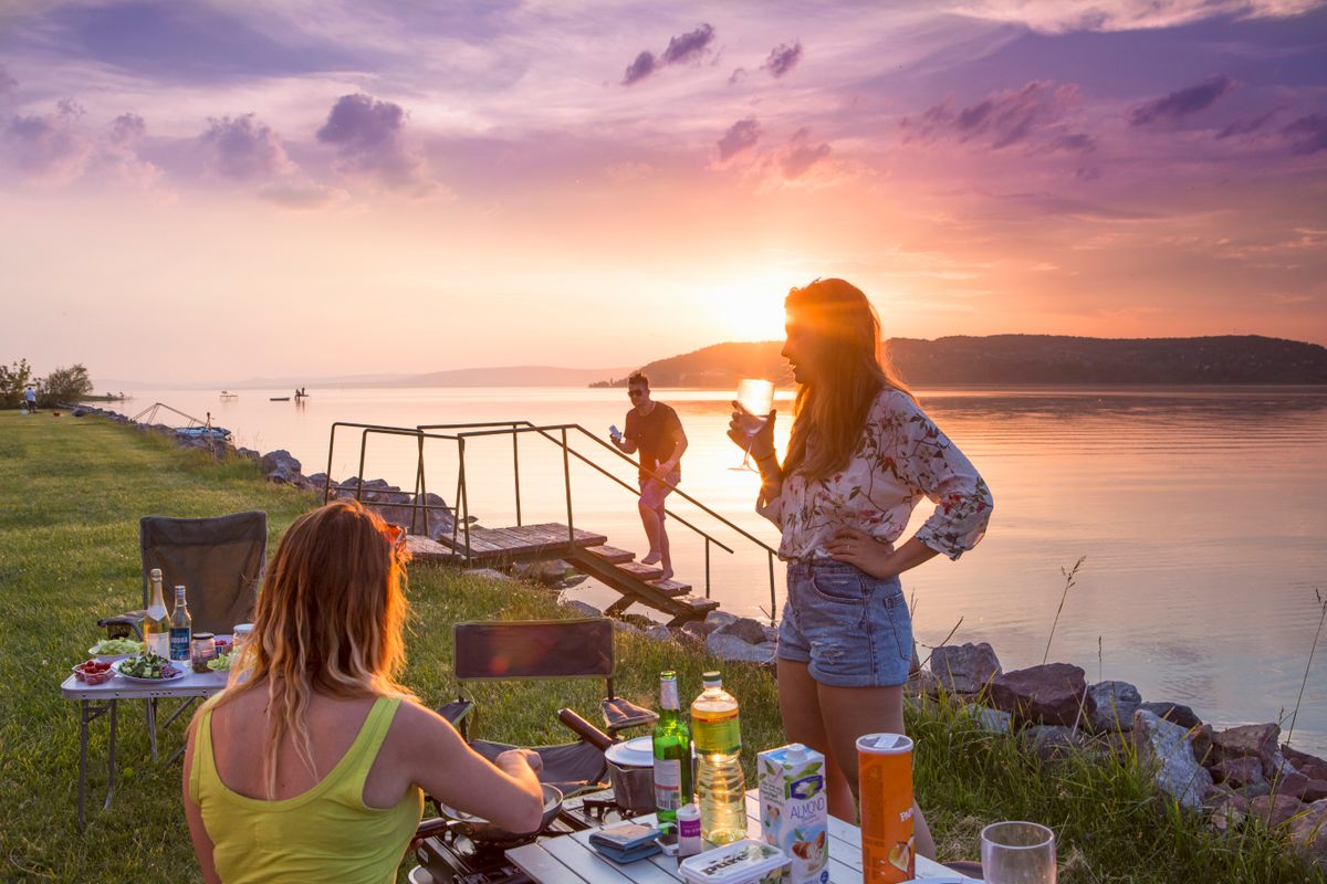 A sunset dinner at a lakeside campsite.
