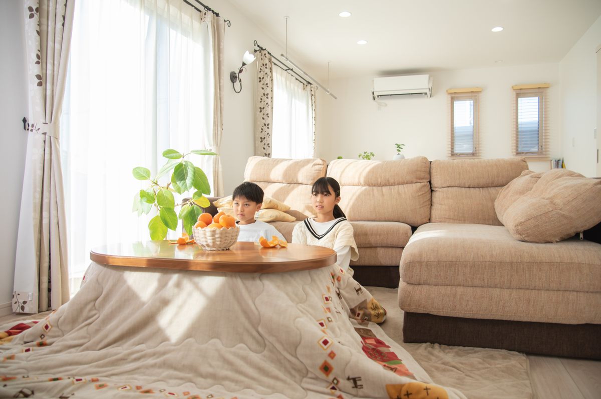 Asian,Child,Eating,Mandarin,Oranges,On,The,Kotatsu,In,The