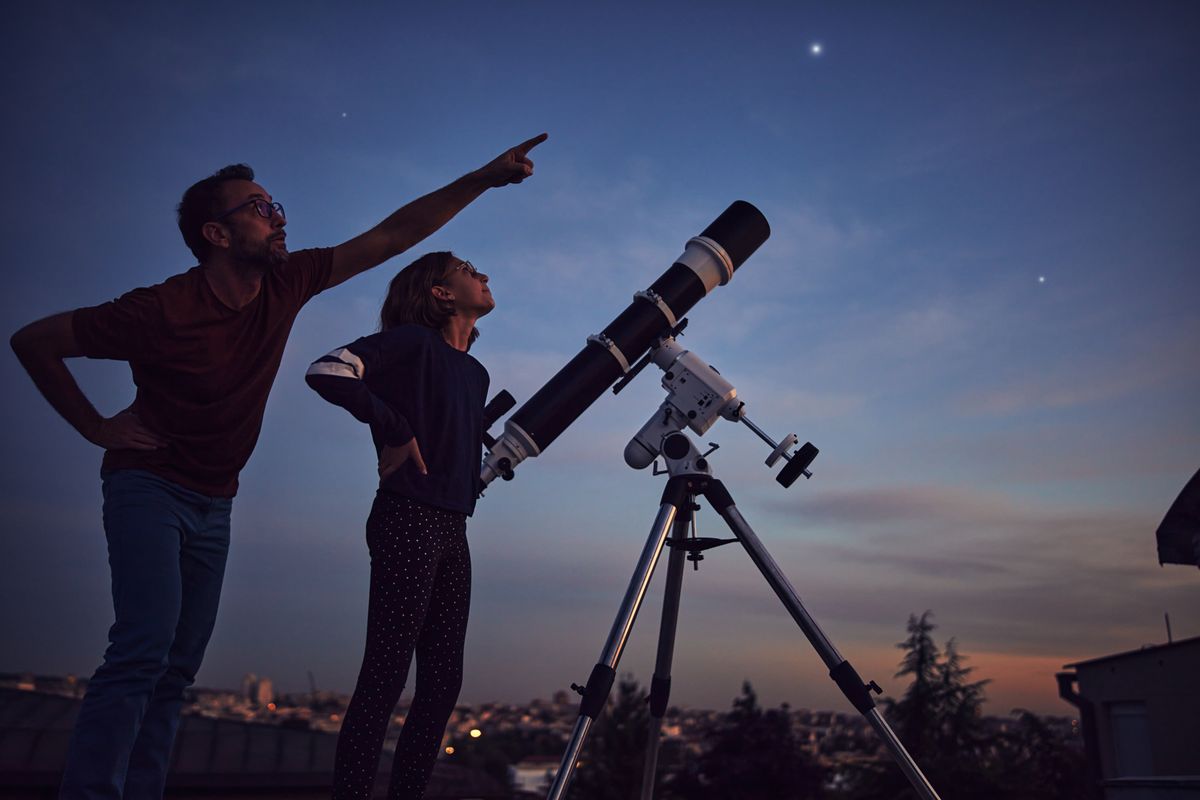 Silhouettes,Of,Father,,Daughter,And,Astronomical,Telescope,Under,Starry,Skies.